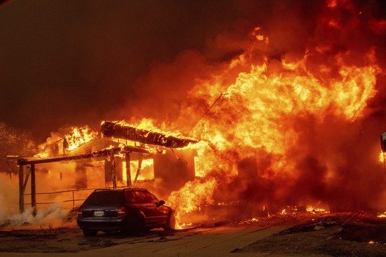 The Eaton Fire engulfs a property Wednesday, Jan. 8, 2025 in Altadena, Calif. (AP Photo/Ethan Swope)