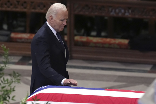 President Joe Biden touches the casket of former President Jimmy Carter during a state funeral service at Washington National Cathedral in Washington, Thursday, Jan. 9, 2025. (AP Photo/Jacquelyn Martin)