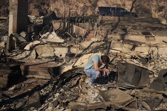 Luke Dexter kneels as he sifts through the remains of his father