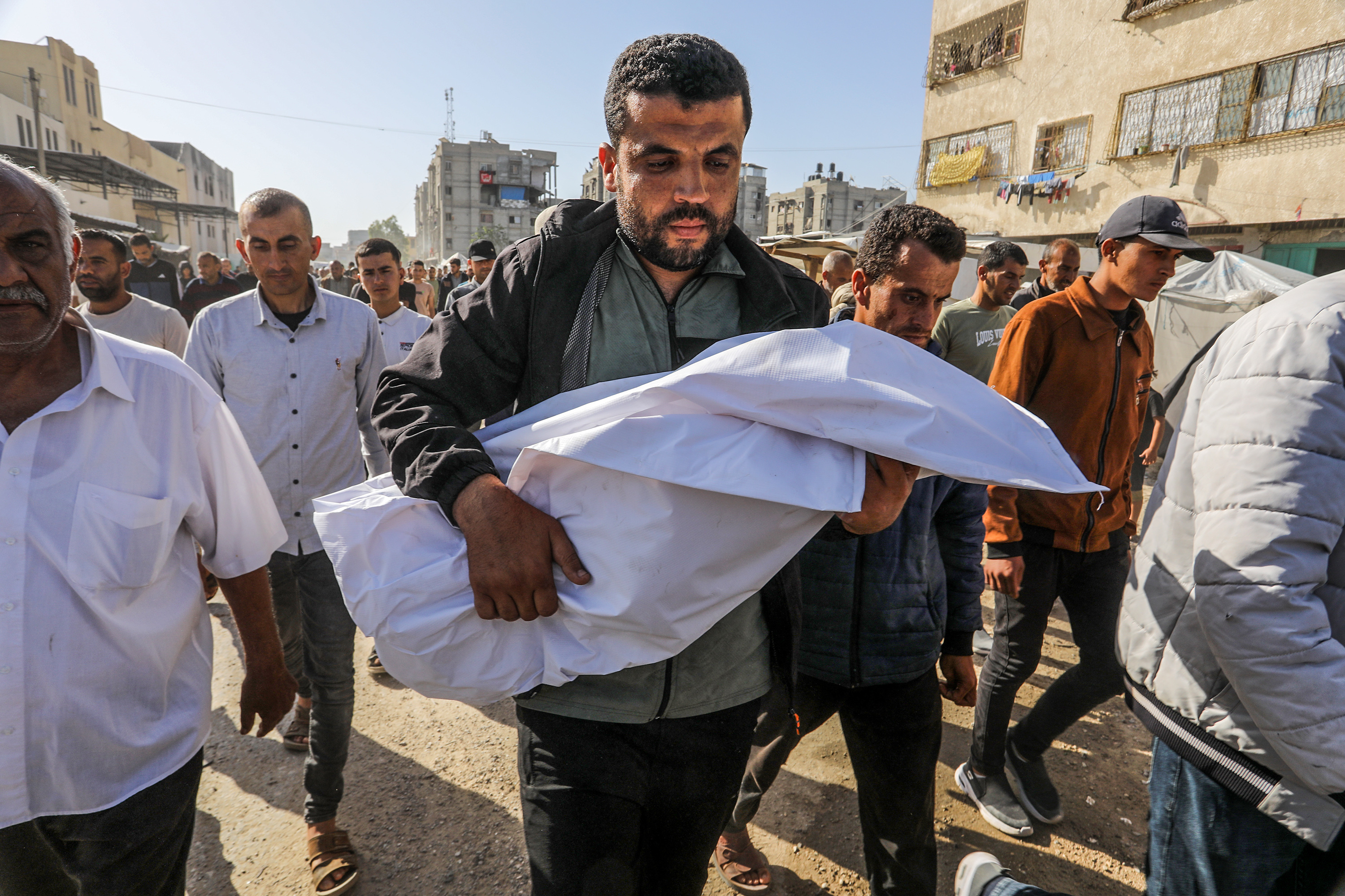 How to Write About Palestine 1 Begin on October 7th, 2023. A man carries a dead child at Nasser Hospital, Khan Yunis, Gaza on May 24, 2025.