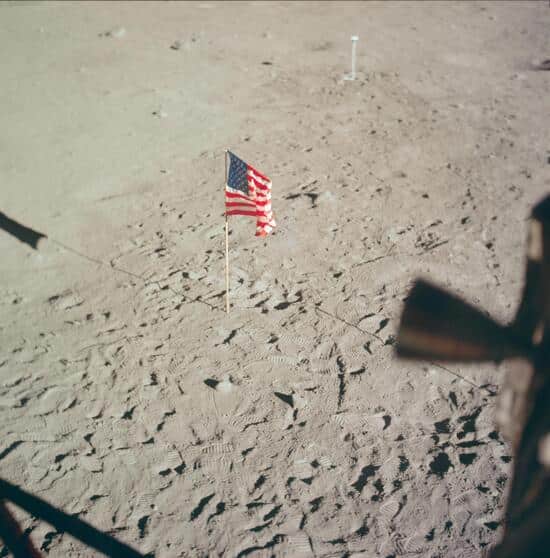 Apollo 11AS11-37-5545 (20 July 1969) --- The flag of the United States, deployed on the surface of the moon, dominates this photograph taken from inside the Lunar Module (LM). The footprints of astronauts Neil A. Armstrong and Edwin E. Aldrin Jr. stand out very clearly. In the far background is the deployed black and white lunar surface television camera which televised the Apollo 11 lunar surface extravehicular activity (EVA). While astronauts Armstrong, commander, and Aldrin, lunar module pilot, descended in the Lunar Module (LM) "Eagle" to explore the Sea of Tranquility region of the moon, astronaut Michael Collins, command module pilot, remained with the Command and Service Modules (CSM) "Columbia" in lunar orbit. Apollo 11AS11-37-5545 (20 July 1969) --- The flag of the United States, deployed on the surface of the moon, dominates this photograph taken from inside the Lunar Module (LM). The footprints of astronauts Neil A. Armstrong and Edwin E. Aldrin Jr. stand out very clearly. In the far background is the deployed black and white lunar surface television camera which televised the Apollo 11 lunar surface extravehicular activity (EVA). While astronauts Armstrong, commander, and Aldrin, lunar module pilot, descended in the Lunar Module (LM) "Eagle" to explore the Sea of Tranquility region of the moon, astronaut Michael Collins, command module pilot, remained with the Command and Service Modules (CSM) "Columbia" in lunar orbit.